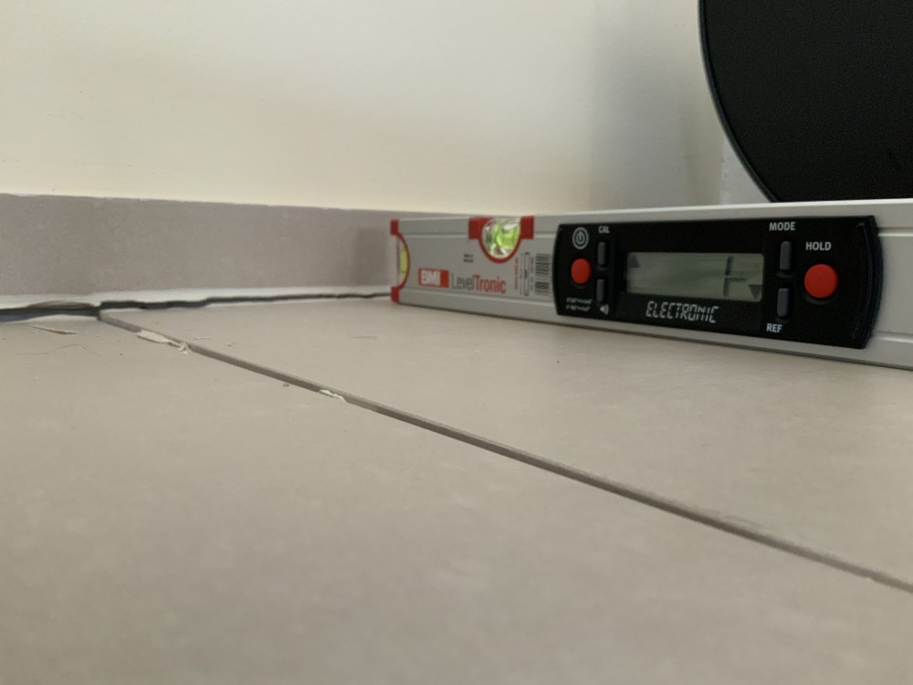 Stufe zur benachbarten Fliese mit Fugenausbruch